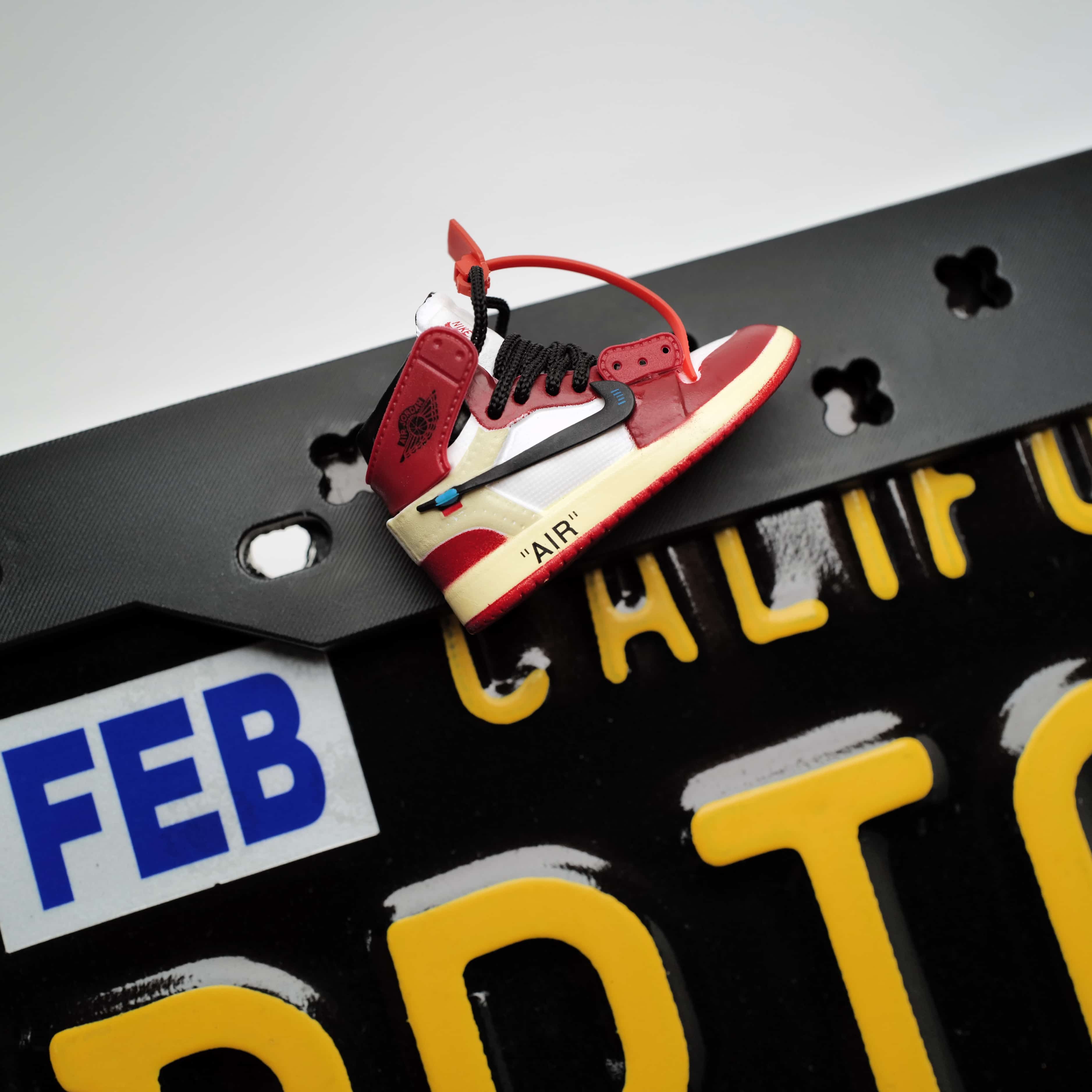 Close-up detail of a highly textured 3D streetwear sneaker charm securely snapped into the flexible Makoauto license plate cover