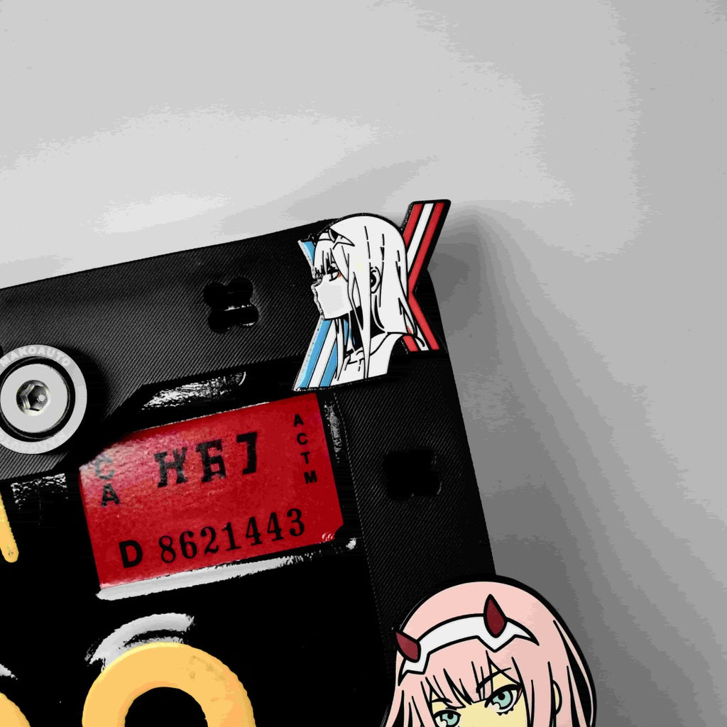 Macro shot of a red 02 number mecha-style charm on the Makoauto customizable vehicle frame