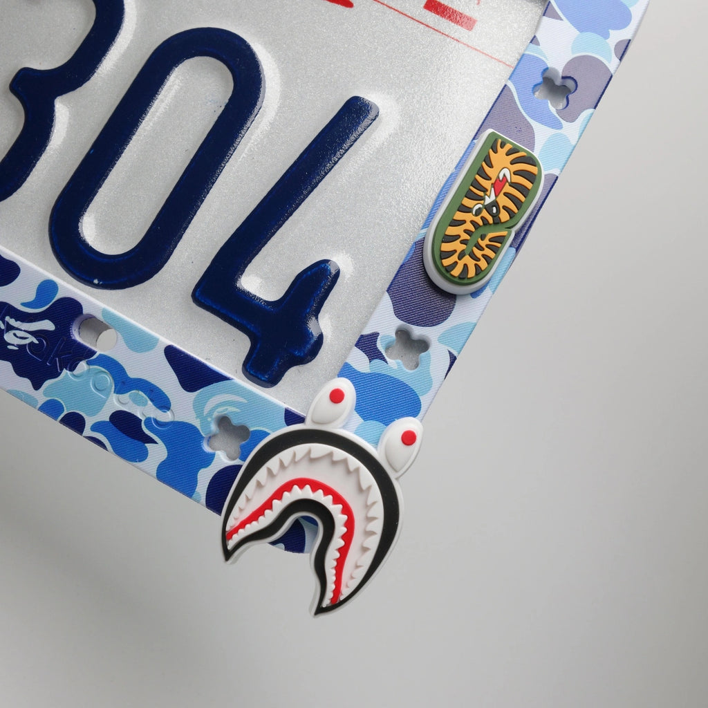 Close up of blue ape head streetwear charm secured in the Makoauto license plate frame