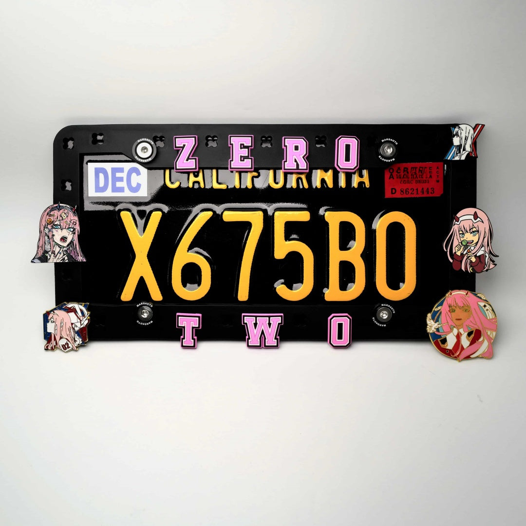 Detailed close-up of a 3D pink-haired anime girl pilot charm attached to the Makoauto patented DIY license plate frame