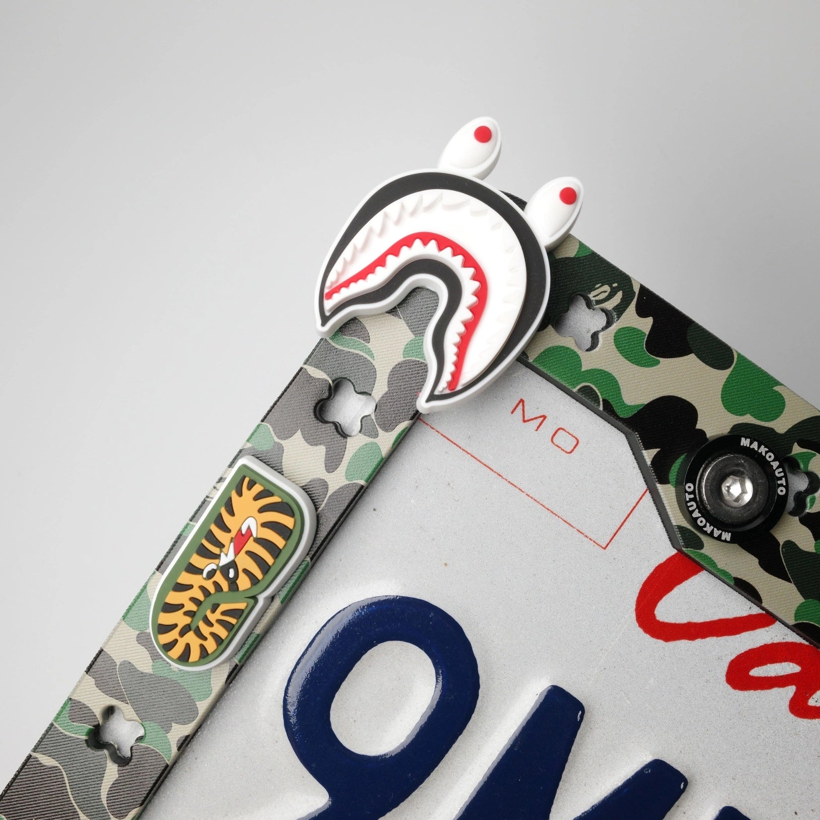 Close up of classic green ape head charm inserted into the Makoauto TPU license plate frame