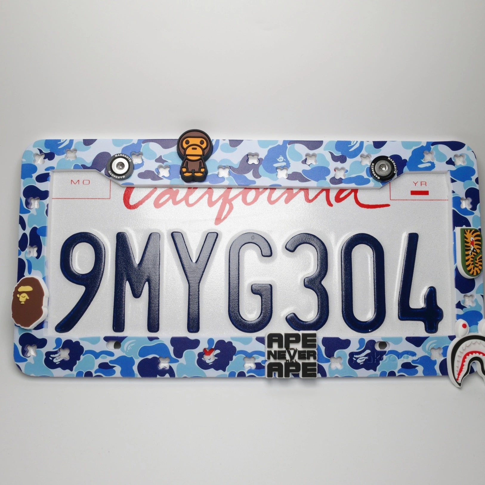Full view of Makoauto ocean blue camo UV printed license plate frame loaded with custom ape charms
