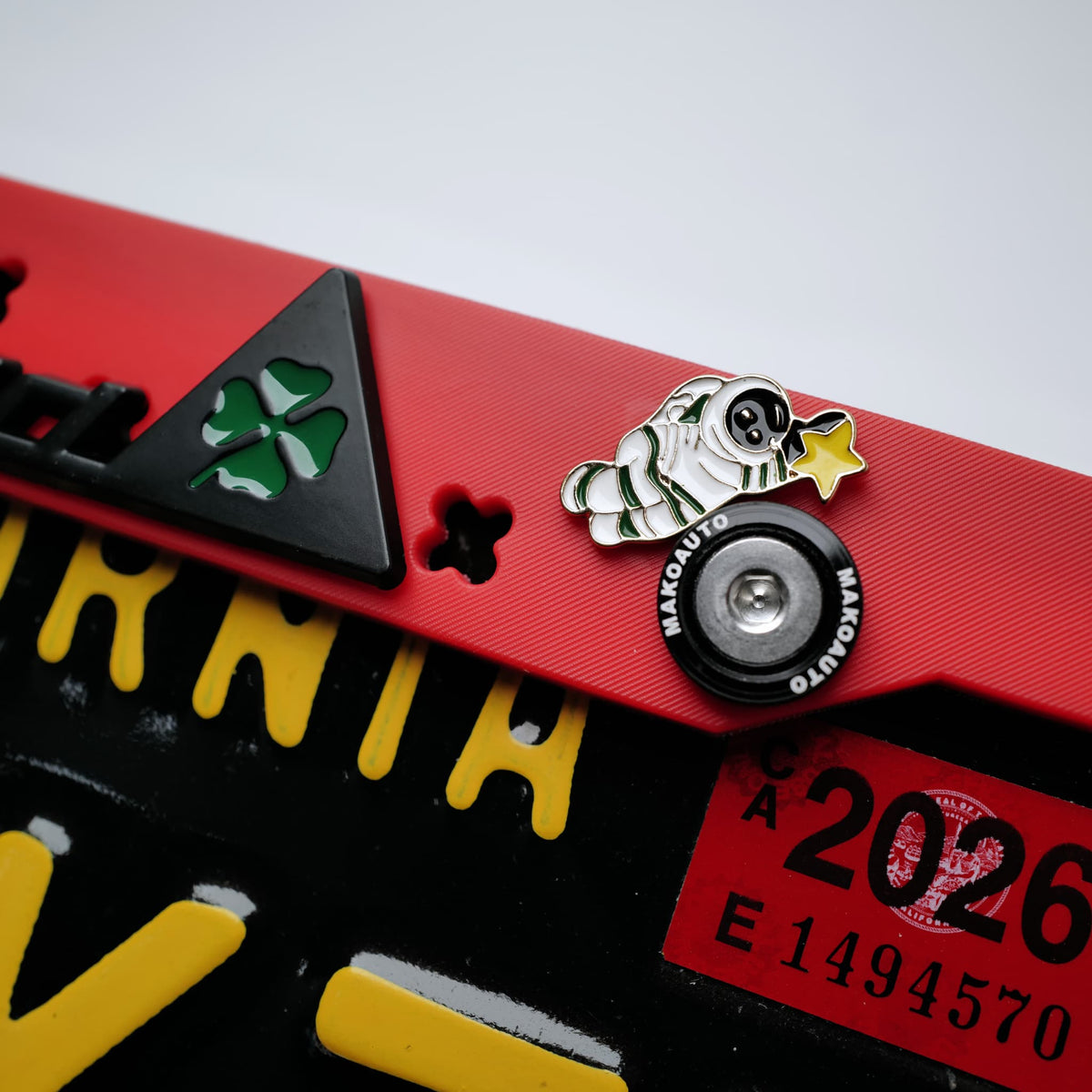 Detail view of the subtle, engraved Makoauto logo at the bottom right corner of the matte red frame.